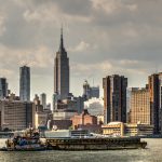 Tugboat, Barge, and NYC Skyline - Photographer: Bonnie Forman-Franco